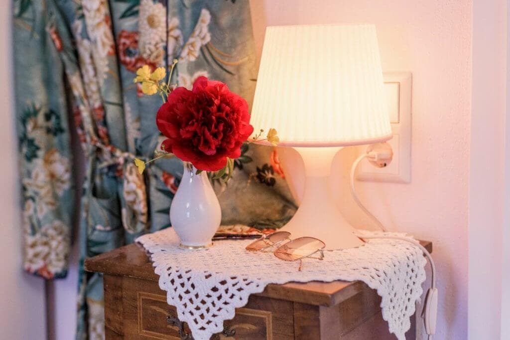 Schöne, dekorative Elemente im Zimmer: Blume mit Porzellanvase und Retrolampe