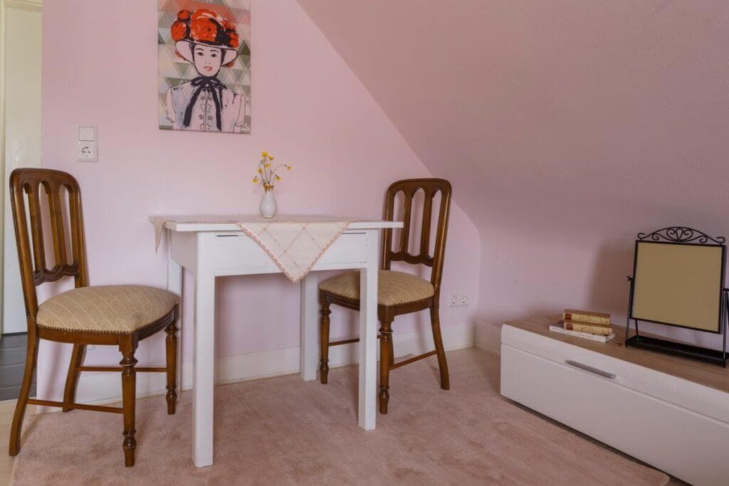 Kleiner, gemütlicher Esstisch mit Dekoration, Tischdecke und Retro-Stühlen